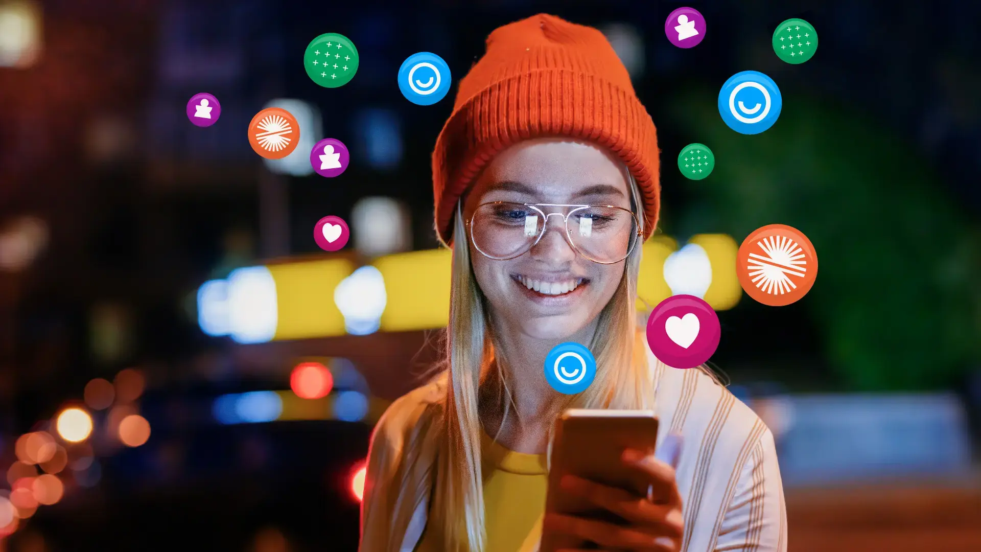 Woman with glasses and orange hat smiling while looking at her phone in front of a blurry cityscape background, colourful circles with white icons surround her