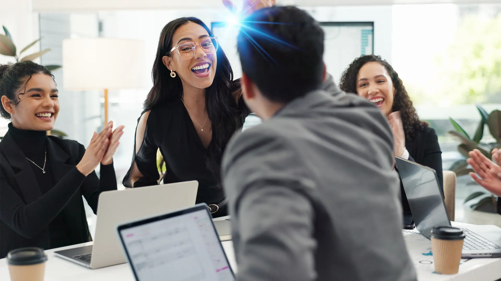 Professionals in a meeting, smiling and high fiving